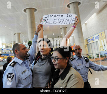 Ein israelischer undercover Polizistin (R) Verhaftungen ein linker Aktivist Holding am 15. April 2012 ein pro-palästinensischen Slogan am Flughafen Ben Gurion in der Nähe von Tel Aviv. Hunderte von Israelischen Polizei, viele überdachte wurden am Flughafen die Ankunft von pro-palästinensischen Aktivisten, die an einer 'Willkommen in Palästina" Fliegen zu blockieren - in eingesetzt. Gelobte Israel Eintrag von Aktivisten zu verhindern, warnen ausländische Fluggesellschaften sie gezwungen wäre, die Rechnung für die sofortige der Aktivisten kehren nach Hause zu Fuß. UPI/Debbie Hill Stockfoto