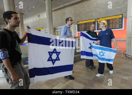 Rechten Israelis halten Sie, um israelische Fahnen gegen linke Aktivisten halten pro-palästinensischen Slogans am Flughafen Ben Gurion in der Nähe von Tel Aviv am 15. April 2012. Hunderte von Israelischen Polizei, viele überdachte wurden am Flughafen die Ankunft von pro-palästinensischen Aktivisten, die an einer 'Willkommen in Palästina" Fliegen zu blockieren - in eingesetzt. Gelobte Israel Eintrag von Aktivisten zu verhindern, warnen ausländische Fluggesellschaften sie gezwungen wäre, die Rechnung für die sofortige der Aktivisten kehren nach Hause zu Fuß. UPI/Debbie Hill Stockfoto