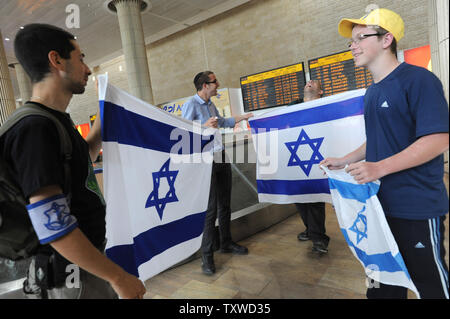 Rechten Israelis halten Sie, um israelische Fahnen gegen linke Aktivisten halten pro-palästinensischen Slogans am Flughafen Ben Gurion in der Nähe von Tel Aviv am 15. April 2012. Hunderte von Israelischen Polizei, viele überdachte wurden am Flughafen die Ankunft von pro-palästinensischen Aktivisten, die an einer 'Willkommen in Palästina" Fliegen zu blockieren - in eingesetzt. Gelobte Israel Eintrag von Aktivisten zu verhindern, warnen ausländische Fluggesellschaften sie gezwungen wäre, die Rechnung für die sofortige der Aktivisten kehren nach Hause zu Fuß. UPI/Debbie Hill Stockfoto