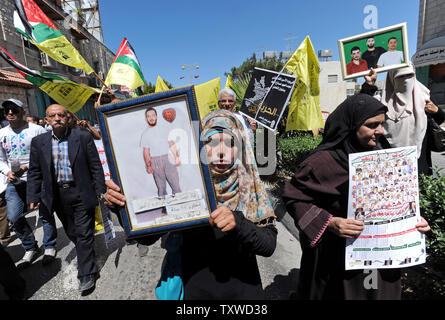 Die Palästinenser tragen Fotos des inhaftierten Verwandten während einer Protestaktion in Solidarität mit den Palästinenser in israelischen Gefangenen auf Häftlinge Tag in die biblische Stadt Bethlehem, West Bank, 17. April 2012 stattfindet. Etwa 1.200 Palästinensische Gefangene in israelischen Gefängnissen begonnen, einen offenen Hungerstreik heute, wie ein weiteres 2.300 verweigert das Essen für einen Tag endete. Es gibt ca. 4.700 Palästinenser in israelischen Gefängnissen. UPI/Debbie Hill Stockfoto