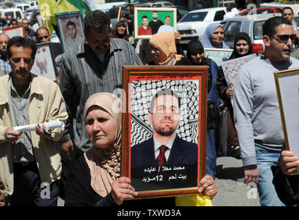 Die Palästinenser tragen Fotos des inhaftierten Verwandten während einer Protestaktion in Solidarität mit den Palästinenser in israelischen Gefangenen auf Häftlinge Tag in die biblische Stadt Bethlehem, West Bank, 17. April 2012 stattfindet. Etwa 1.200 Palästinensische Gefangene in israelischen Gefängnissen begonnen, einen offenen Hungerstreik heute, wie ein weiteres 2.300 verweigert das Essen für einen Tag endete. Es gibt ca. 4.700 Palästinenser in israelischen Gefängnissen. UPI/Debbie Hill Stockfoto