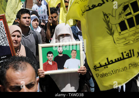 Die Palästinenser tragen Fotos des inhaftierten Verwandten während einer Protestaktion in Solidarität mit den Palästinenser in israelischen Gefangenen auf Häftlinge Tag in die biblische Stadt Bethlehem, West Bank, 17. April 2012 stattfindet. Etwa 1.200 Palästinensische Gefangene in israelischen Gefängnissen begonnen, einen offenen Hungerstreik heute, wie ein weiteres 2.300 verweigert das Essen für einen Tag endete. Es gibt ca. 4.700 Palästinenser in israelischen Gefängnissen. UPI/Debbie Hill Stockfoto