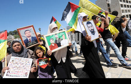 Die Palästinenser tragen Fotos des inhaftierten Verwandten während einer Protestaktion in Solidarität mit den Palästinenser in israelischen Gefangenen auf Häftlinge Tag in die biblische Stadt Bethlehem, West Bank, 17. April 2012 stattfindet. Etwa 1.200 Palästinensische Gefangene in israelischen Gefängnissen begonnen, einen offenen Hungerstreik heute, wie ein weiteres 2.300 verweigert das Essen für einen Tag endete. Es gibt ca. 4.700 Palästinenser in israelischen Gefängnissen. UPI/Debbie Hill Stockfoto