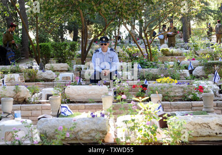 Ein israelischer Soldat sitzt durch die Gräber der gefallenen Soldaten am Memorial Day in der Mt. Herzl Soldatenfriedhof in Jerusalem, 25. April 2012. Memorial Day erinnert an israelische Soldaten seit 1948 gesunken, vor dem die Feier des 64. Jahrestages der Gründung des Staates Israel. UPI/Debbie Hill Stockfoto