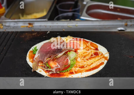 Tortilla Pizza auf dem Grill. Gesunde und herzhaftes Essen, fajita mit gegrilltem Schinken, Gemüse, frische Salsa, serviert sehr heiß. Konzept national food Stockfoto