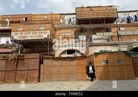 Eine ultra-orthodoxe jüdische Mann vor der Wohnanlage, wo Balkone mit sukkahs, temporäre Wohnungen abgedeckt sind, während der jüdische Feiertag von Sukkot, am Fest der Laubhütten, in Mea Shearim, Jerusalem, Israel, 30. September 2012 verwendet werden. Die Sukkot Urlaub erinnert sich an die vierzig Jahre wohnten die Söhne Israel in der Wüste Sinai nach ihrem Auszug aus Ägypten. Religiöse Juden essen und schlafen in temporären Wohnungen für sieben Tage und Nächte und beten mit den vier Arten, die umfassen: ETROG (Zitrone), Lulav (Palme Wedel, hadas (myrtenzweige) und aravot (weidenzweige). UPI/Debbie Hi Stockfoto