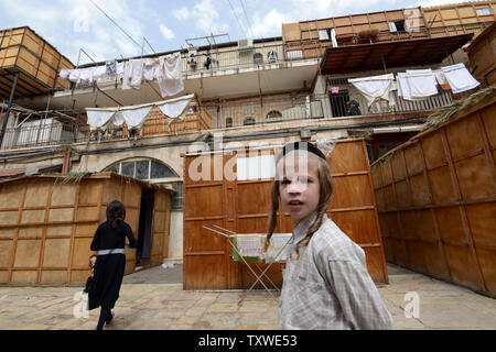 Eine ultra-orthodoxe jüdische Junge steht vor der Wohnanlage, wo Balkone mit sukkahs, temporäre Wohnungen abgedeckt sind, während der jüdische Feiertag von Sukkot, am Fest der Laubhütten, in Mea Shearim, Jerusalem, Israel, 30. September 2012 verwendet werden. Die Sukkot Urlaub erinnert sich an die vierzig Jahre wohnten die Söhne Israel in der Wüste Sinai nach ihrem Auszug aus Ägypten. Religiöse Juden essen und schlafen in temporären Wohnungen für sieben Tage und Nächte und beten mit den vier Arten, die umfassen: ETROG (Zitrone), Lulav (Palme Wedel, hadas (myrtenzweige) und aravot (weidenzweige). UPI/Debbie H Stockfoto