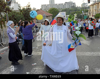 Israelis wave Pro-Israel Christen aus den Philippinen, wie sie in der jährlichen Jerusalem Parade während der Sukkot Urlaub, oder Fest der Tablernacles, im Zentrum von Jerusalem, Israel, 4. Oktober 2012. Mehr als 5.000 Christen aus über 100 Ländern strömten nach Jerusalem, am Fest der Laubhütten Urlaub ihre Unterstützung für Israel und das jüdische Volk, an einer Veranstaltung der Internationalen Christlichen Botschaft in Jerusalem gefördert zu zeigen. UPI/Debbie Hill Stockfoto