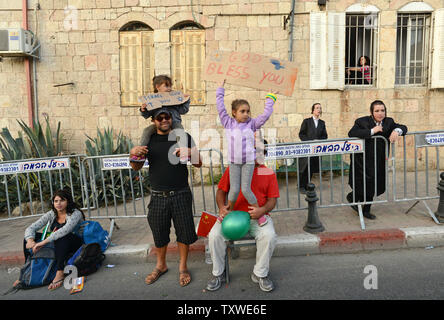 Die Israelis halten Schildern mit der Aufschrift "Gott segne dich" für Pro-Israel Christen, nicht gesehen, marschieren in den jährlichen Jerusalem Parade während der Sukkot Urlaub, oder Fest der Tablernacles, im Zentrum von Jerusalem, Israel, 4. Oktober 2012. Mehr als 5.000 Christen aus über 100 Ländern strömten nach Jerusalem, am Fest der Laubhütten Urlaub ihre Unterstützung für Israel und das jüdische Volk, an einer Veranstaltung der Internationalen Christlichen Botschaft in Jerusalem gefördert zu zeigen. UPI/Debbie Hill Stockfoto