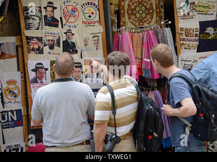 Eine touristische Punkte an digital verbesserte t-shirts mit Fotos von US-Präsident Barack Obama als ultra-orthodoxe Juden, Palästinenser und Osama Bin Laden außerhalb einer sourvenir Shop in der Altstadt von Jerusalem, Israel, November 10, 2012. Verschiedene Führer der Welt werden auch angezeigt, einschließlich der republikanische Präsidentschaftskandidat Mitt Romney. UPI/Debbie Hill Stockfoto