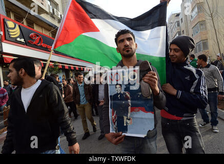 Eine palästinensische Proteste den bevorstehenden Besuch von US-Präsident Barack Obama mit einem Schuh- und Plakat lesen "keine Hoffnung" bei einer Demonstration in Ramallah, West Bank, 19. März 2013. Präsident Obama ist wie ein israelischer Soldat vor einem Tank auf dem Poster dargestellt. Der US-Präsident kommt in Israel am Mittwoch für drei Tage besuchen. Der palästinensische Präsident Mahmud Abbas wird Gastgeber der Präsident Obama in Ramallah am Donnerstag. UPI/Debbie Hill Stockfoto