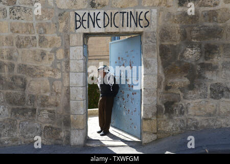 Ein palästinensischer Mann steht am Eingang zu einem Kloster vor dem traditionellen Palmsonntag Prozession vom Ölberg auf die Altstadt von Jerusalem, Israel, 24. März 2013. Der Palmsonntag ist der triumphale Eintrag von Jesus Christus auf einem Esel nach Jerusalem, wo er von den Massen winkende Palmen die Woche, bevor er gekreuzigt wurde, begrüßt wurde. UPI/Debbie Hill Stockfoto