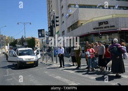 Israelis Anschlag auf der Straße zwei Minuten Stille zu beobachten, wie eine Sirene, die Ringe über das Land Israels Gefallenen auf Tag der Erinnerung in Jerusalem, Israel, 15. April 2013 zu Ehren. Der feierlichen Tag der Erinnerung an die 23,085 Soldaten, die in der Linie der Aufgabe fiel zu dem Schluss in der Dämmerung, wenn die Feierlichkeiten für Israels 65th Tag der Unabhängigkeit beginnen. UPI/Debbie Hill Stockfoto