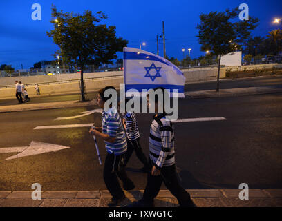 Ultra-orthodoxe jüdische Jungen tragen die Flagge nach dem traditionellen Fahne Tanz Prozession auf Jerusalem Tag außerhalb der Damaskus Tor in Ost-jerusalem, 8. Mai 2013. Tausende von Israelis auf die Straße gingen, Jerusalem Day, der den 46. Jahrestag der Wiedervereinigung Jerusalems Markierungen nach Osten Jerusalem von Jordanien im Sechs-Tage-Krieg 1967 gefangen genommen wurde, zu feiern. UPI/Debbie Hill Stockfoto