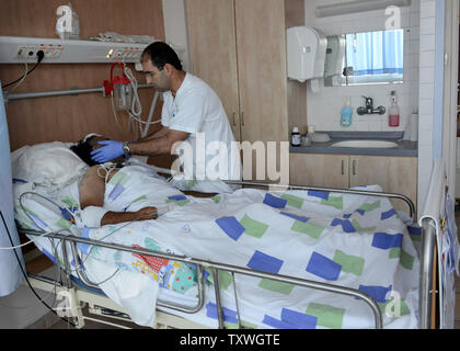 Eine Krankenschwester behandelt eine syrische Mann in die anhaltende Gewalt in Syrien verwundet in der neurologischen Abteilung der Israelischen westlichen Galiläa Medical Center in Nahariya, im Norden Israels, 22. September 2013. Mehr als 90 Syrische Opfer in der israelischen Krankenhaus seit März 2013 für lebensrettende medizinische Behandlungen behandelt. UPI/Debbie Hill Stockfoto