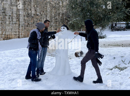 Palästinenser bauen einen Schneemann außerhalb der Mauern der Altstadt von Jerusalem, Israel, 13. Dezember 2013. Eine frühe großen Sturm hat Teile des Nahen Ostens mit schweren Schnee bedeckt, was zu Störungen in der Strom- und der Schließung von Schulen und Straßen in Jerusalem. UPI/Debbie Hill Stockfoto