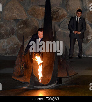 Der britische Premierminister David Cameron zündet die ewige Flamme in der "Halle der Erinnerung" an der Yad Vashem Holocaust Museum in Jerusalem, Israel, 12. März 2014. Die Trauerfeier geehrt, die sechs Millionen Juden, die unter den Nazis während des Zweiten Weltkriegs umgekommen Es ist Camerons erster Staatsbesuch in Israel und den Palästinensischen Gebieten.. UPI/Debbie Hill. Stockfoto