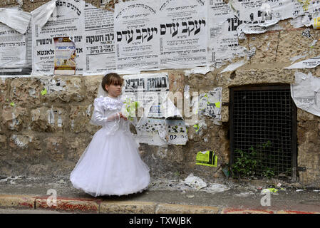 Eine ultra-orthodoxe jüdische Mädchen trägt eine Braut Kostüm am Fest Purim in Mea Shearim in Jerusalem, Israel, 17. März 2014. Die purim Urlaub erinnert an die Befreiung des jüdischen Volkes von Völkermord im alten Persien, wie sie im Buch Esther erzählt. UPI/Debbie Hügel. Stockfoto