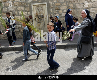 Eine christliche Junge trägt eine Palm Zweig während der jährlichen Palmsonntag Prozession auf dem Ölberg in Jerusalem, Israel, 13. April 2014. Lokale und internationale Christen ging den Pfad, wo Jesus Christus ein Esel in Jerusalem vor mehr als 2.000 Jahren ritt. Der Palmsonntag ist der Beginn der Heiligen Woche. UPI/Debbie Hill Stockfoto