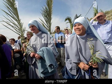 Katholische Nonnen tragen Palmzweige während der jährlichen Palmsonntag Prozession auf dem Ölberg in Jerusalem, Israel, 13. April 2014. Lokale und internationale Christen ging den Pfad, wo Jesus Christus ein Esel in Jerusalem vor mehr als 2.000 Jahren ritt. Der Palmsonntag ist der Beginn der Heiligen Woche. UPI/Debbie Hill Stockfoto