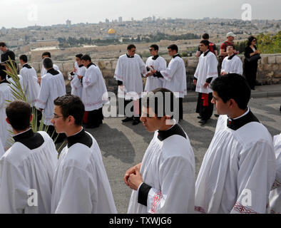 Katholisches Priesterseminar Studenten gehen in der jährlichen Palmsonntag Prozession mit Blick auf die Altstadt von Jerusalem auf dem Ölberg in Jerusalem, Israel, 13. April 2014. Lokale und internationale Christen ging den Pfad, wo Jesus Christus ein Esel in Jerusalem vor mehr als 2.000 Jahren ritt. Der Palmsonntag ist der Beginn der Heiligen Woche. UPI/Debbie Hill Stockfoto