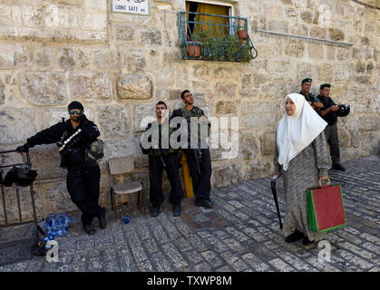 Eine ältere palästinensische Frau geht Vergangenheit israelische Grenzpolizisten in der Altstadt von Jerusalem, 18. September 2015, auf dem Weg zur muslimischen Freitagsgebet in der Al-Aqsa-Moschee. Die israelische Polizei beschränkt Eintrag der Al-Aqsa Moschee Verbindung zu den Männern über 40 Jahren nach drei Tagen der gewalttätigen Auseinandersetzungen zwischen israelischen und palästinensischen Jugendlichen während der jüdischen Feiertage. Foto von Debbie Hill/UPI Stockfoto