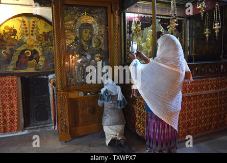 Eine äthiopische Frau kniet nieder und betet vor eine Madonna mit Kind Symbol in der Geburtskirche, wo Tradition glaubt, dass Jesus Christus geboren wurde, in Betlehem, West Bank, 20. Dezember 2015. Foto von Debbie Hill/UPI Stockfoto