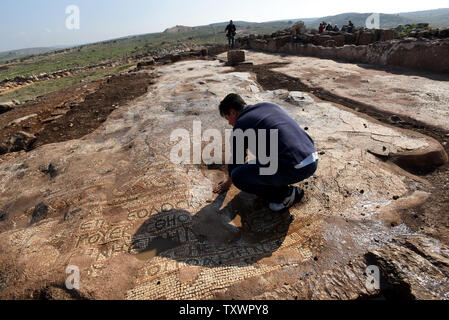 Ein Mann entfernt Wasser aus einer alten Mosaik auf dem Boden einer 1,5000 Jahr alten byzantinischen Kloster von 500 CE, ausgegraben, die von den israelischen Antiquities Authority in Rosh Ha-Ayin, in der Nähe von Tel Aviv, Israel, 30. Dezember 2015. Das Kloster wurde entdeckt, weil Archäologen müssen alle neuen Baustellen und eine neue Nachbarschaft wird in der Region prüfen. Das Kloster eine Kirche untergebracht, eine Ölpresse, Wohnquartiere für ca. 30 Personen und Stallungen. Es ist eine griechische Inschrift in bunten Mosaiken, die lautet: "Dieser Ort unter Theodosius der Priester gebaut wurde. Der Friede sei mit dir, wenn Sie kommen, ein Stockfoto