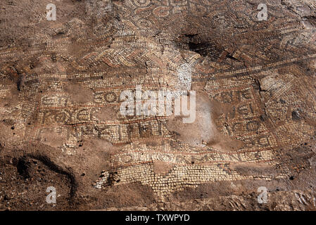 Ein Blick auf eine antike Inschrift in einem Mosaik in einer 1,5000 Jahr alten byzantinischen Kloster von 500 CE entdeckt, ausgegraben, die von den israelischen Antiquities Authority in Rosh Ha-Ayin, in der Nähe von Tel Aviv, Israel, 30. Dezember 2015. Das Kloster wurde entdeckt, weil Archäologen müssen alle neuen Baustellen und eine neue Nachbarschaft wird in der Region prüfen. Das Kloster eine Kirche untergebracht, eine Ölpresse, Wohnquartiere für ca. 30 Personen und Stallungen. Es ist eine griechische Inschrift in bunten Mosaiken, die lautet: "Dieser Ort unter Theodosius der Priester gebaut wurde. Der Friede sei mit dir, wenn Sie kommen, ein Stockfoto