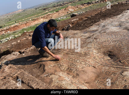 Der israelische Archäologe Amit Shadman reinigt ein Mosaik in einem neu entdeckten 1,5000 Jahr alten byzantinischen Kloster von 500 CE, ausgegraben, die von den israelischen Antiquities Authority in Rosh Ha-Ayin, in der Nähe von Tel Aviv, Israel, 30. Dezember 2015. Das Kloster wurde entdeckt, weil Archäologen müssen alle neuen Baustellen und eine neue Nachbarschaft wird in der Region prüfen. Das Kloster eine Kirche untergebracht, eine Ölpresse, Wohnquartiere für ca. 30 Personen und Stallungen. Es ist eine griechische Inschrift in bunten Mosaiken, die lautet: "Dieser Ort unter Theodosius der Priester gebaut wurde. Der Friede sei mit dir, wenn yo Stockfoto