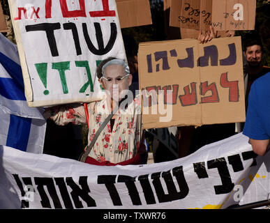 Ein israelischer Demonstrant trägt eine Maske mit einem Porträt von Premierminister Benjamin Netanjahu hält ein Schild mit der Aufschrift "Netanjahu ins Gefängnis gehen sollte" bei einem Protest gegen eine Erdgas beschäftigen, die die US-Firma Noble Energie, ausserhalb des Obersten Gerichtshofes in Jerusalem, Israel, 14. Februar 2016 enthält. Netanjahu hat einen noch nie da gewesenen Auftritt in der Oberste Gerichtshof seine Erdgas Politik zu verteidigen Nach fünf Petitionen gegen sie durch Parteien, die sagen, daß er seine Macht verwendet, um die Einwände der Kartellbehörde seiner wirtschaftlichen Verbündeten zu erfüllen und die Unternehmen dafür zu umgehen eingeordnet wurden. Foto von Debbie Hil Stockfoto