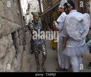 Israelis tragen Kostüme der jüdische Feiertag Purim in Jerusalem, Israel, 25. März 2016 zu feiern. Purim ist ein freudiger Urlaub, feiert das Heil der Juden von Völkermord im alten Persien, wie sie im Buch Esther erzählt. Foto von Debbie Hill/UPI Stockfoto