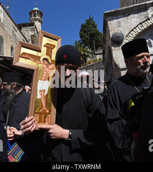 Ein orthodoxer Priester trägt ein Kreuz auf der Via Dolorosa in der Altstadt von Jerusalem am Karfreitag, 29. April 2016. Karfreitag erinnert an den Weg, den Jesus sein Kreuz zu seiner Kreuzigung auf Golgatha durchgeführt. UPI Stockfoto