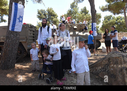 Ein israelischer Siedler Besuche von Familienangehörigen eine militärische Ausstellung auf Israels 68th Tag der Unabhängigkeit auf Munition Hügel in Jerusalem, Israel, 12. Mai 2016. Foto von Debbie Hill/UPI Stockfoto