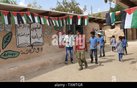 Palästinensischen Beduinen Kinder zu Fuß außerhalb des Khan Al Ahmar Schule in der West Bank, 17. August 2016. Die adobe Schule wurde 2009 mit internationalen Geldern errichtet und dient 160 Schüler von der ersten bis zur neunten Klasse. Der palästinensischen Autonomiebehörde eine Kampagne ruft die internationale Gemeinschaft auf, die Israel zivile Verwaltung von Abriss der Schule, die mit Abriss Bestellungen im Jahr 2009 herausgegeben wurde, begonnen hat. In der Nähe der Israelischen Siedler haben neue Petitionen an das Hohe Gericht eingeordnet, die Schule und die Beduinen Camps, wo rund 100 Familien, die in der Wüste leben zu zerstören. Foto von Debbie Hill/UPI Stockfoto