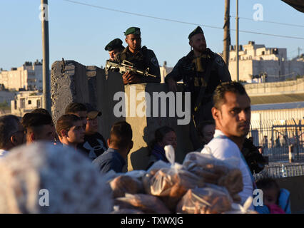 Palästinensischen Anbeter warten die Sicherheit Israels am Qalandiya Checkpoint, West Bank, auf ihre Weise das Freitagsgebet auf dem dritten Freitag des muslimischen Fastenmonats Ramadan an der Al-Aqsa Moschee in der Altstadt von Jerusalem, 16. Juni 2017 teilnehmen. Die qalandiya Checkpoint ist Teil der israelischen Trennungsmauer, Ramallah im Westjordanland von Jerusalem trennt. Foto von Debbie Hill/UPI Stockfoto