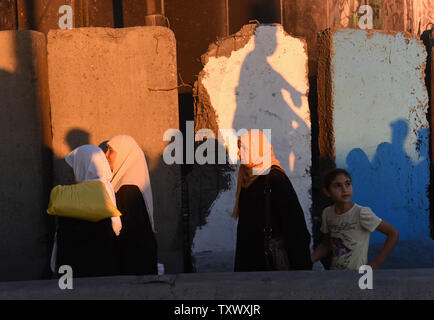 Palästinensischen Anbeter warten die Sicherheit Israels am Qalandiya Checkpoint, West Bank, auf ihre Weise das Freitagsgebet auf dem dritten Freitag des muslimischen Fastenmonats Ramadan an der Al-Aqsa Moschee in der Altstadt von Jerusalem, 16. Juni 2017 teilnehmen. Die qalandiya Checkpoint ist Teil der israelischen Trennungsmauer, Ramallah im Westjordanland von Jerusalem trennt. Foto von Debbie Hill/UPI Stockfoto