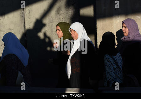 Der Schatten eines israelischen Soldaten als palästinensische Anbeter warten die Sicherheit Israels am Qalandiya Checkpoint, West Bank, auf ihre Weise das Freitagsgebet auf dem dritten Freitag des muslimischen Fastenmonats Ramadan an der Al-Aqsa Moschee in der Altstadt von Jerusalem, 16. Juni 2017 teilnehmen. Die qalandiya Checkpoint ist Teil der israelischen Trennungsmauer, Ramallah im Westjordanland von Jerusalem trennt. Foto von Debbie Hill/UPI Stockfoto