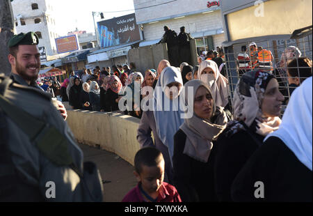 Eine israelische Grenzpolizei Lächeln als palästinensische Anbeter warten in der Linie der Qalandiya Checkpoint, West Bank, auf ihre Weise das Freitagsgebet auf dem dritten Freitag des muslimischen Fastenmonats Ramadan an der Al-Aqsa Moschee in der Altstadt von Jerusalem, 16. Juni 2017 teilnehmen. Die qalandiya Checkpoint ist Teil der israelischen Trennungsmauer, Ramallah im Westjordanland von Jerusalem trennt. Foto von Debbie Hill/UPI Stockfoto