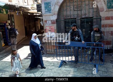 Palästinenser vorbei an israelische Sicherheitskräfte in der Altstadt von Jerusalem, Juli 15, 2017. Der Tempelberg blieb auf muslimische Gläubige für den zweiten Tag geschlossen, nachdem israelische Araber zwei Israelische Polizisten bei einem Shooting Angriff am Freitag getötet. Spannungen entbrannt zwischen Jordanien und Israel, wenn ein jordanisches Sprecher beschuldigt israelischen Verstöße gegen den Status quo von Muslimen Verbot von Gebet auf dem Berg. Der israelische Premierminister Benjamin Netanjahu sagte, dass seine Regierung die Sicherheitslage am Sonntag bewerten würde. - Foto von Debbie Hill/UPI Stockfoto