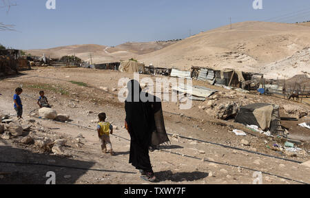 Beduinen Spaziergang im Khan Al Ahmar Dorf in der Judäischen Wüste in der West Bank, 25. September 2017, in der Nähe von Kfar Adumim jüdische Siedlung. Israel wird gesetzt, Pläne nächste Woche für rund 2.000 neue Häuser in den Siedlungen im Westjordanland zu gelangen. Siedler in Kfar Adumim haben die israelischen High Court wandten, um Abriss einer Schule und Strukturen im Bedouin Village in der Nähe von Khan Al-Ahmar durchführen, wird der Weg für Ausbau der Siedlungen zu löschen. Foto von Debbie Hill/UPI Stockfoto