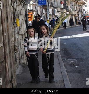 Ultra-orthodoxe jüdische Jungen tragen ein lulav oder palm Zweig, eine der vier Arten während der Woche verwendet - lange Jüdische Festival von Sukkot, das Laubhüttenfest, in Mea Shearim, Jerusalem, Israel, 1. Oktober 2017. Die Sukkot Urlaub beginnt bei Sonnenuntergang am Mittwoch, 4. Oktober und erinnert an die Juden Auszug aus Ägypten vor rund 3.200 Jahren. Juden bauen sukkahs, provisorische Hütten, zu Essen, Schlaf während der Ferien- und. Foto von Debbie Hill/UPI Stockfoto