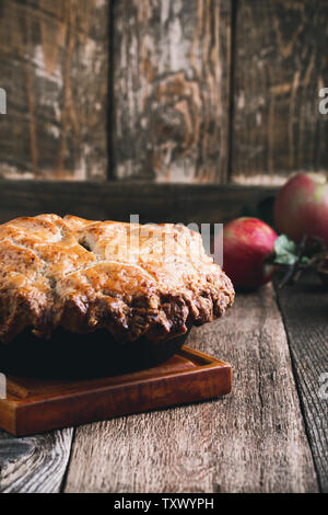 Apfelkuchen in Gusseisen Skillet, traditionelle Thanksgiving Nachtisch, Herbst gemütliche Teller auf ländlichen Holztisch, Nahaufnahme, selektiver Fokus Stockfoto