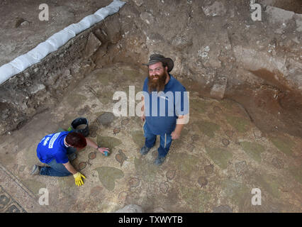 Benyamin Storchan, Leiter der Ausgrabungen, der Israel Antiquities Authority, steht auf einem Mosaikboden in die Überreste einer 1,5000 Jahre alten byzantinischen Periode Kloster und Kirche während der umfangreichen Ausgrabungen in Beit Shemesh, Israel, 20. Dezember 2017 aufgedeckt. Die Byzantinische Struktur wurde bei Ausgrabungen vor der Erweiterung von Ramat Beit Shemesh für Gehäuse entdeckt. Das bunte Mosaik Boden ist mit Vögeln, treibt und granatäpfel eingerichtet. Artefakte gefunden und eine Reihe von architektonischen Elementen, wie z. B. einem Marmor Säule base mit Kreuzen und Marmor Fenster Geröll eingerichtet Stockfoto