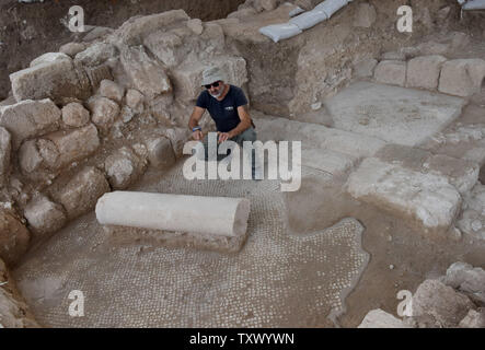 Naftali Aizik, ein Archäologe mit dem Israel Antiquities Authority, kniet in der Reste einer 1,5000 Jahre alten byzantinischen Periode Kloster und Kirche während der umfangreichen Ausgrabungen in Beit Shemesh, Israel, 20. Dezember 2017 aufgedeckt. Die Byzantinische Struktur wurde bei Ausgrabungen vor der Erweiterung von Ramat Beit Shemesh für Gehäuse entdeckt. Das bunte Mosaik Boden ist mit Vögeln, treibt und granatäpfel eingerichtet. Artefakte gefunden und eine Reihe von architektonischen Elementen, wie z. B. einem Marmor Säule base mit Kreuzen und Marmor Fenster eingerichtet. Die Artefakte gefunden Mai Anzeige Stockfoto