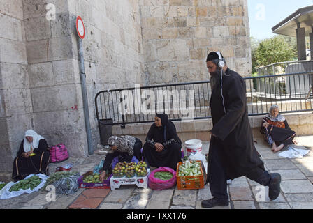 Eine ultra-orthodoxe Juden trägt Kopfhörer, während er an die Palästinenser den Verkauf produzieren in das Damaskus Tor in der Altstadt von Jerusalem, Juli 15, 2018. Die israelische Knesset ist diese Woche auf der umstrittenen Nationalstaat Gesetz, das jüdische Werte über die demokratischen priorisieren würde zu stimmen. Der Ultranationalistischen Gesetz erlaubt Israel Gemeinschaften, die durch die Religion oder Nationalität ausgesondert worden sind. Der israelische Premierminister Benjamin Netanjahu ist für das Gesetz, während amerikanische jüdische Führer und gemäßigten Israelischen sagen, es ist ein "Rassistisch und diskriminierend" Rechnung. Foto von Debb Stockfoto