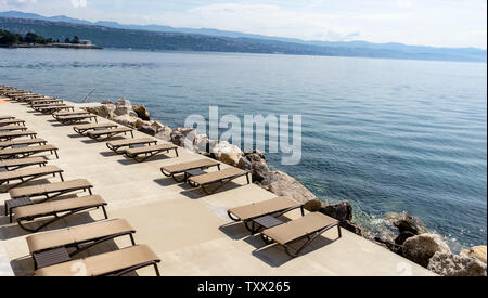 Strand mit Sonnenschirmen und Liegestühlen, bereit für den Sommer. Kroatien Opatija. Stockfoto