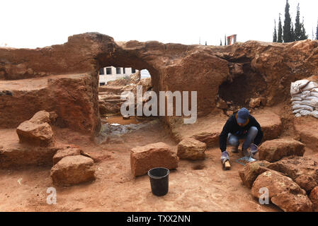 Ein Arbeitnehmer, der von der Israel Antiquities Authority reinigt den Eingang zu einer 2000 Jahre alten Grabstätte Immobilien von einem jüdischen Dorf aus dem Hasmonean Periode in der arabischen Nachbarschaft von sharafat in Jerusalem, 27. März 2019. Die Ausgrabungen haben die extravaganten Beerdigung Immobilien, eine Olivenpresse, rituelle Bäder, Mikwe offenbart, und ein Taubenschlag. Foto von Debbie Hill/UPI Stockfoto