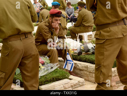 Ein israelischer Soldat sitzt durch die Gräber der gefallenen Soldaten im Mt. Herzl Soldatenfriedhof in Jerusalem, auf Israels Erinnerung Tag für Soldaten und Terror Opfer, 8. Mai 2019. Tausende von Israelis in Soldatenfriedhöfe im ganzen Land gesammelt 23,741 Soldaten und 3.150 terror Opfer zu erinnern. Foto von Debbie Hill/UPI Stockfoto