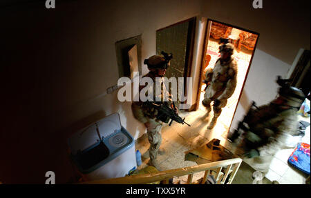 Elemente von Charlie Company 1-184 th Infanterie der Kalifornischen Army National Guard, 4. Brigade der 3 ID angeschlossen ist, führen Sie eine Razzia in einem aufständischen Haus, in Bagdad, Irak, am 11. April 2005. Mehr als 500 irakische Sicherheitskräfte, die in Zusammenarbeit mit der Task Force Bagdad Soldaten, durchsucht mehr als 90 Ziele und 65 mutmaßliche Terroristen festgenommen in der Al-Rasheed Bezirk Razzien Montag morgen früh in Bagdad. (UPI Foto/Ken James) Stockfoto